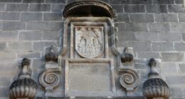 Escudo e inscrição em pedra na parede de uma construção histórica